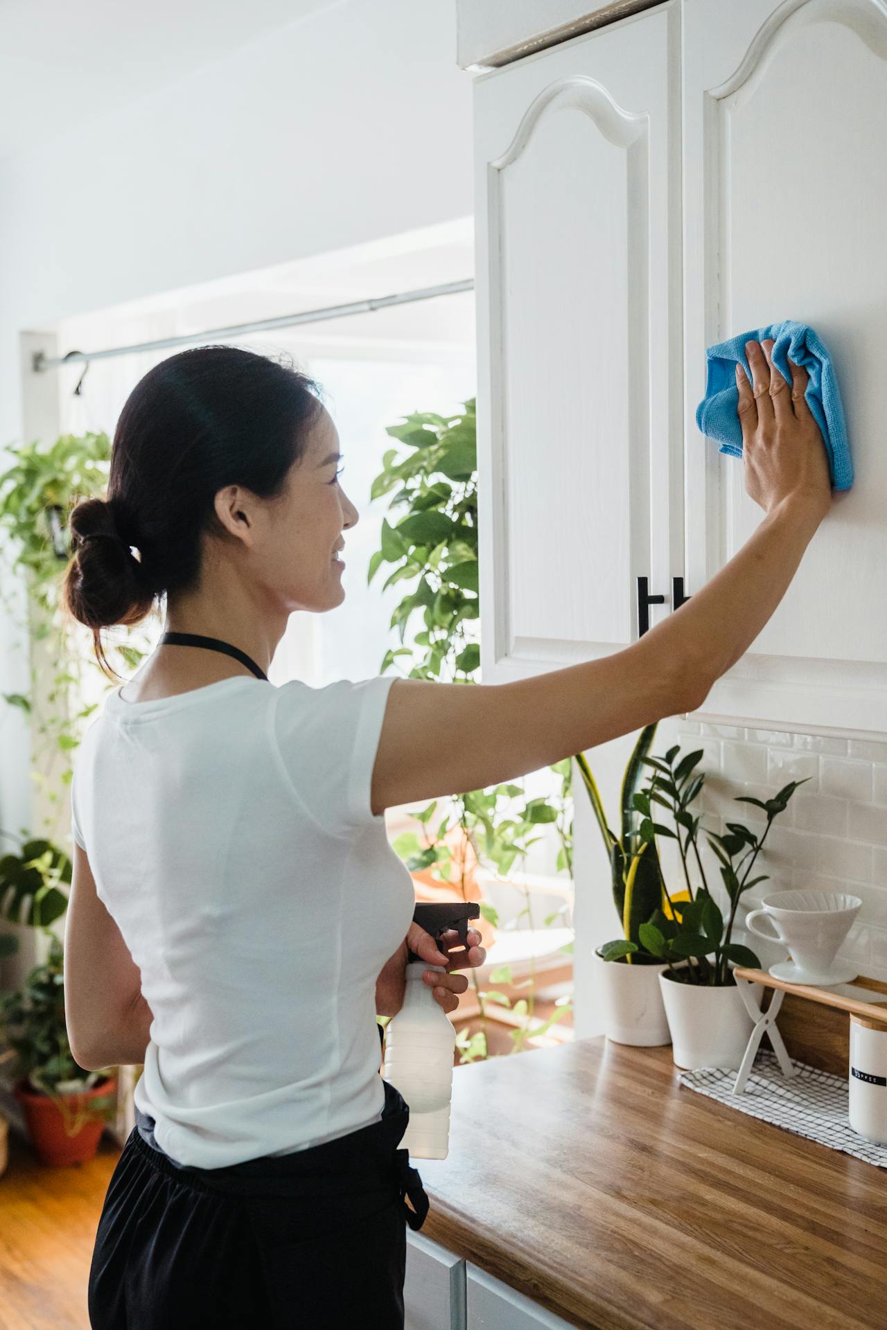 Inspecting and wiping kitchen cabinets before applying primer